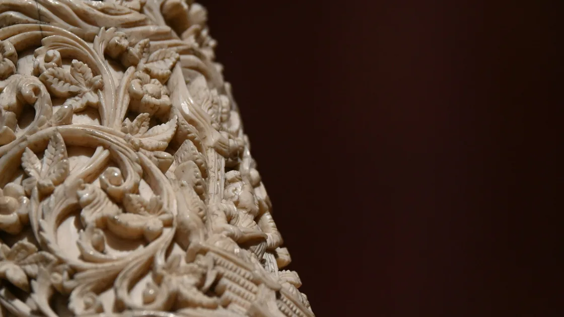 Detail jemné prořezávané ornamentální řezby na světlém kostěném předmětu